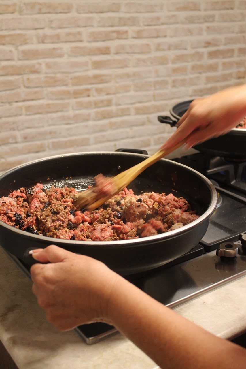 Mamá Patty guisando la carne del picadillo en una sartén grande.