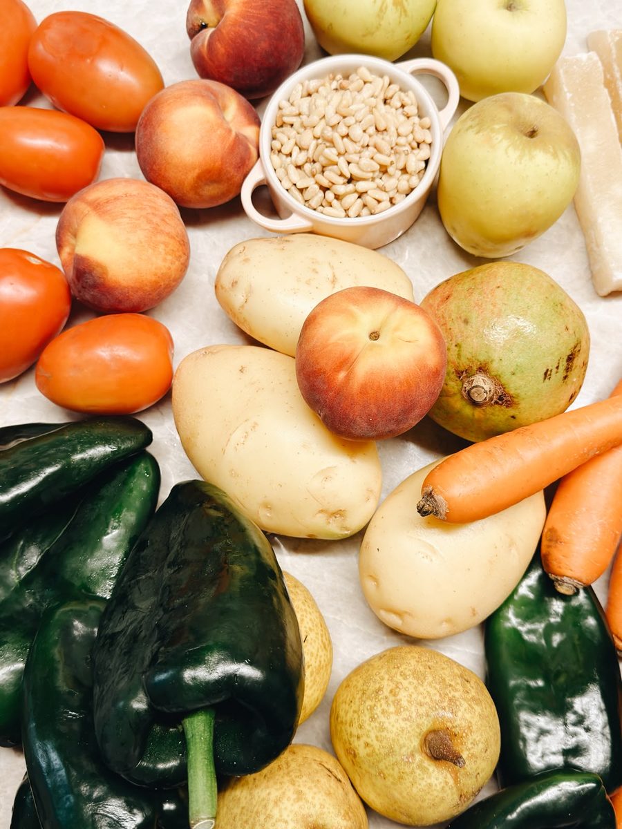Poblanos, duraznos, manzana panochera, pera de leche, granada, jitomate y piñones sobre la mesa, recién llegados del mercado.