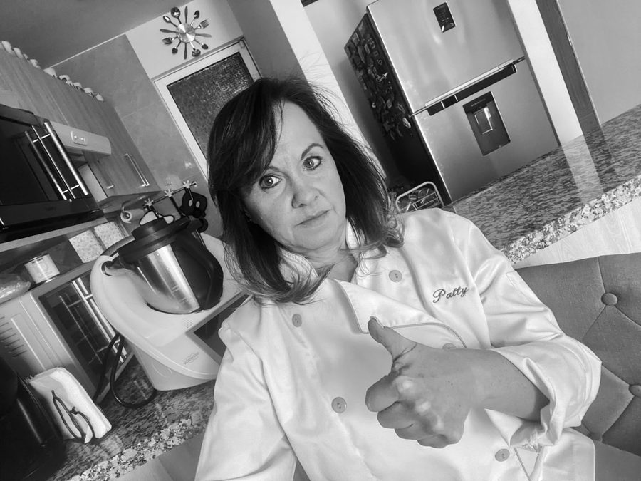 Mamá Patty muy seria dando el pulgar arriba en su cocina.